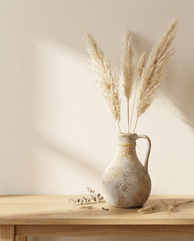 Pitcher vase with dried pampas on oak console table